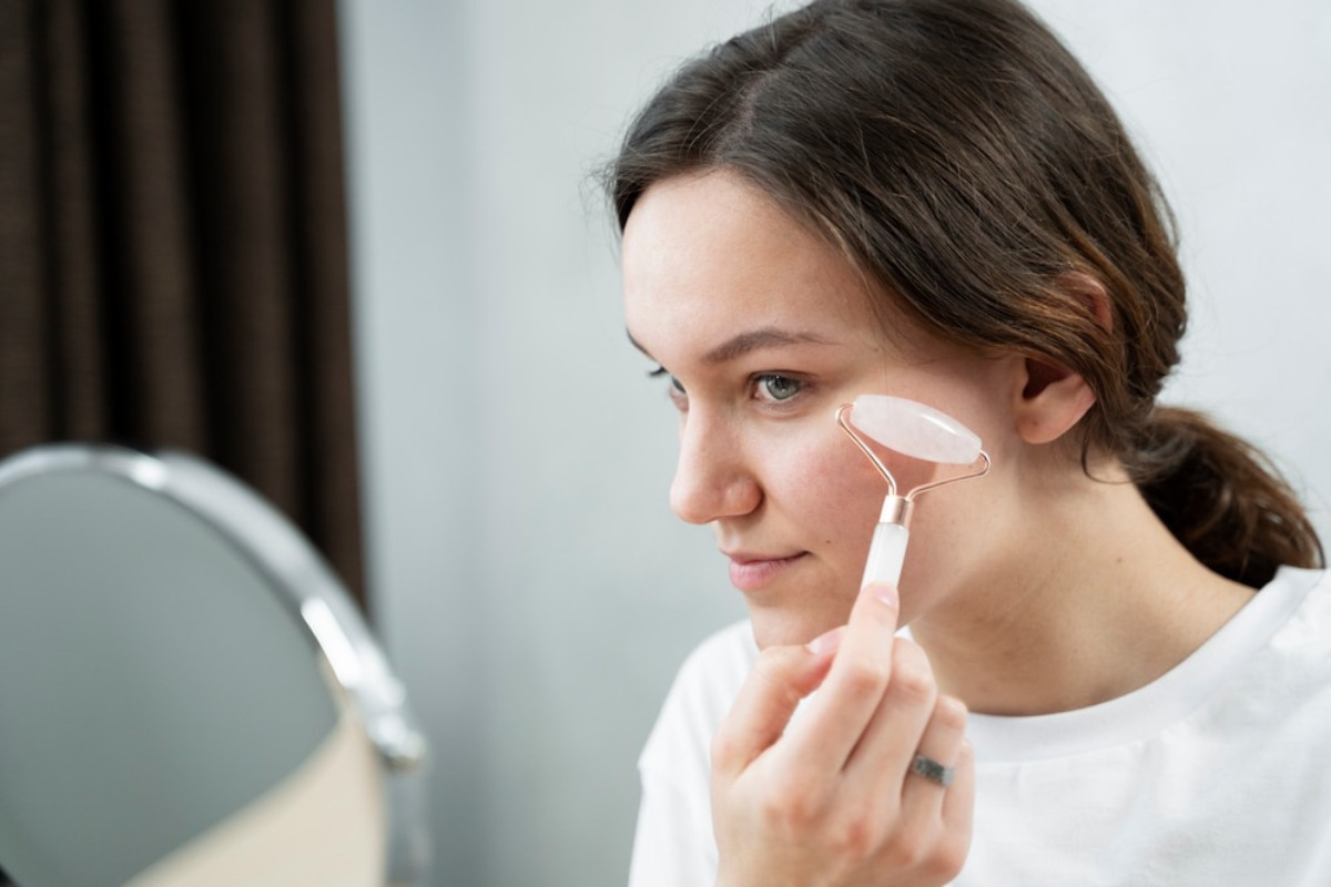 A person is looking into a mirror while holding a makeup brush, with soft, blurred background elements enhancing the scene.